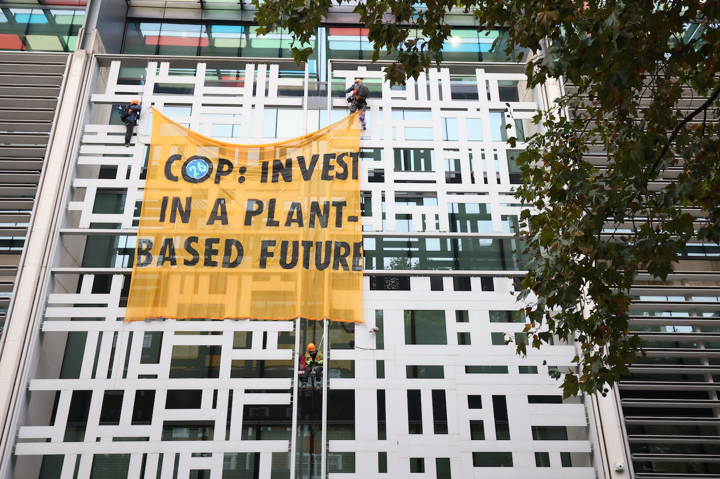 A sign on a building says "COP: Invest in a plant-based future"