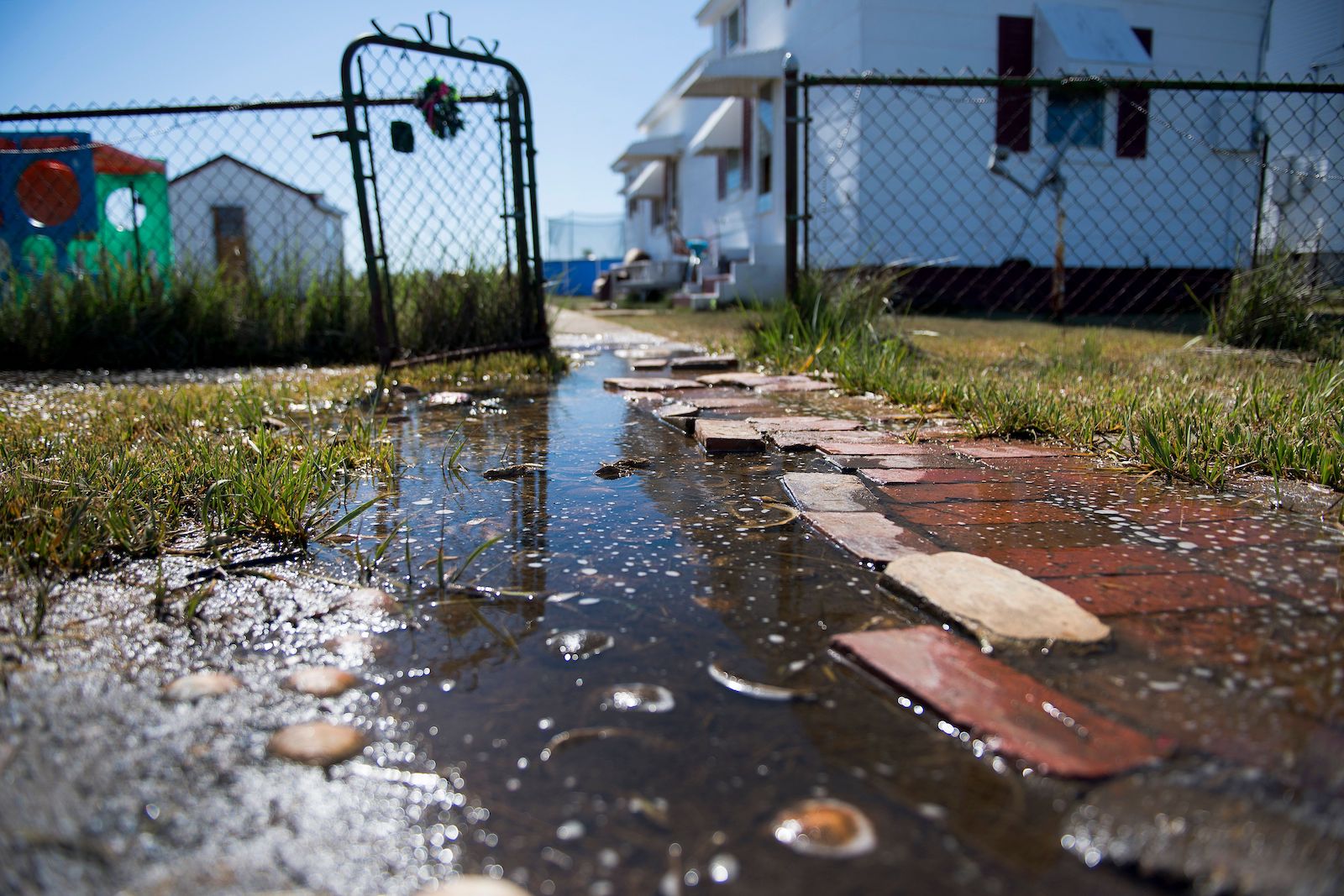 Sea water collects on the front walk way of a home in Tangier, Virginia, May 15, 2017, where climate change and rising sea levels threaten the inhabitants of the slowly sinking island.