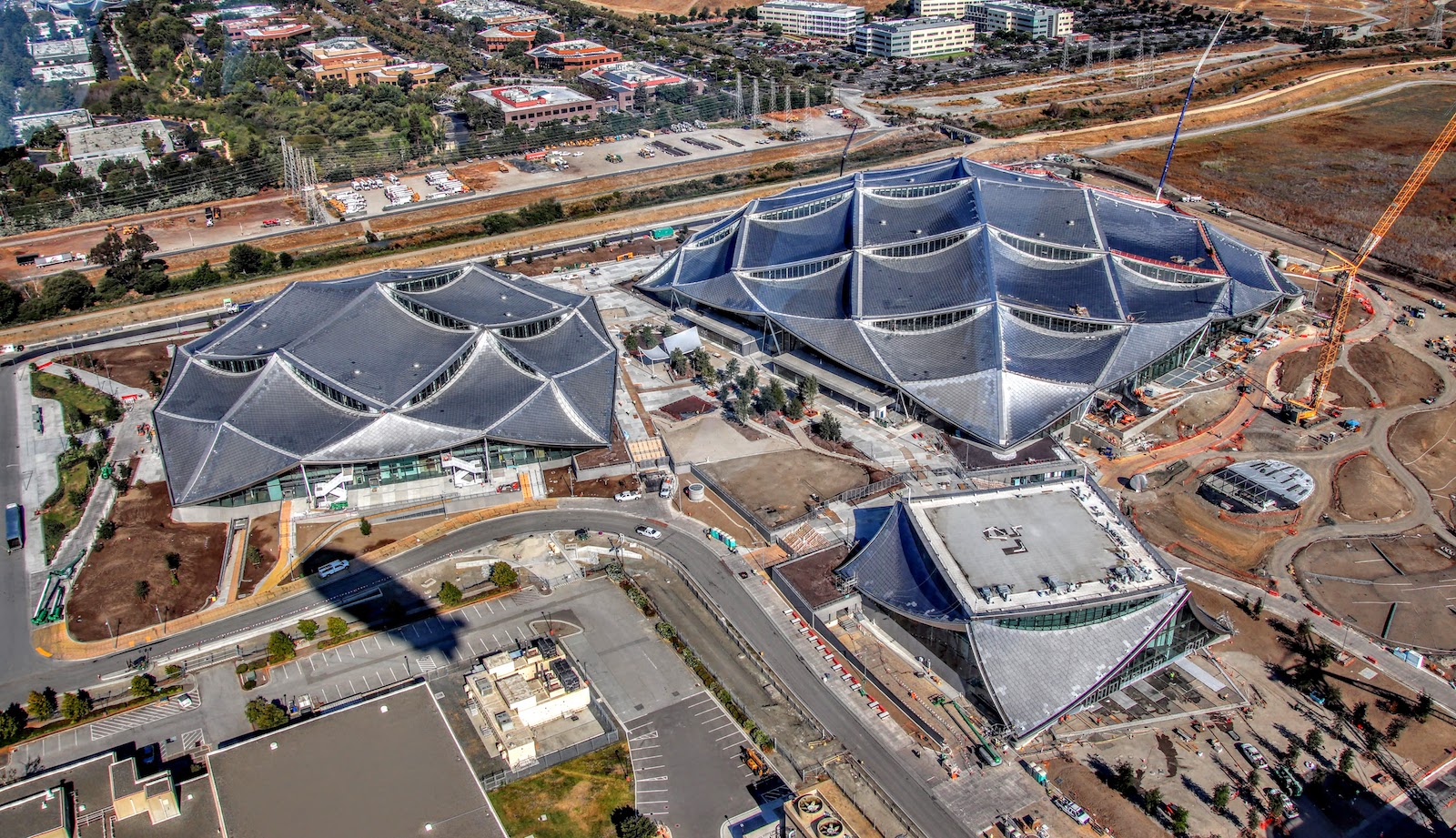two large buildings with scale-like roofs with multiple, curved peaks as seen from above