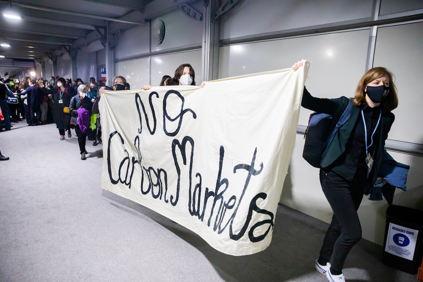 Protesters at COP26 carry a sign that says no carbon markets
