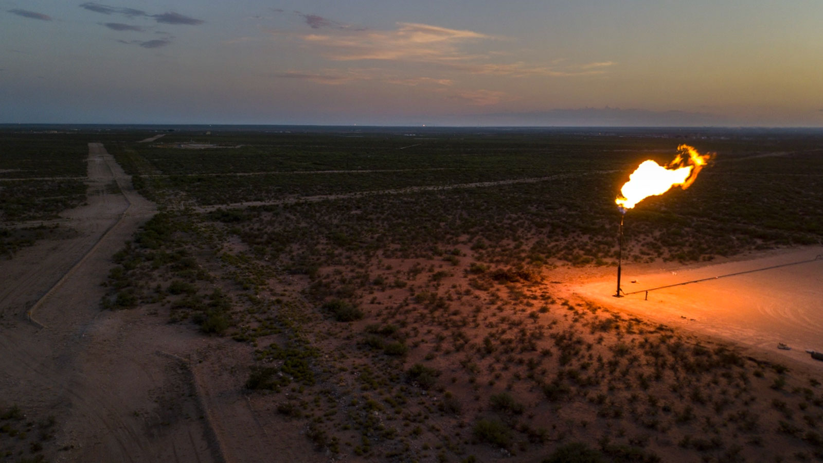 A gas flare burns at dusk in the Permian Basin in Texas, U.S.