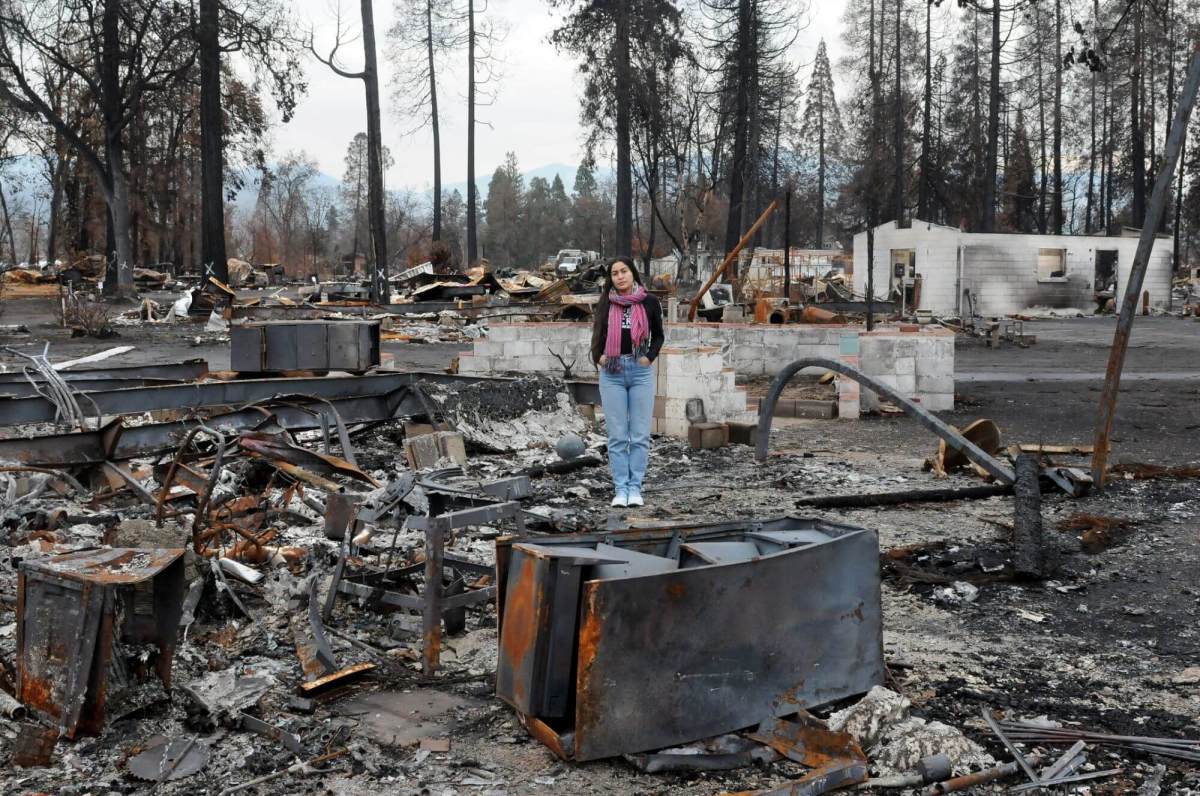 Climate activist Niria Garcia stands amid the burned-out remains of her father’s home in Phoenix, Ore.