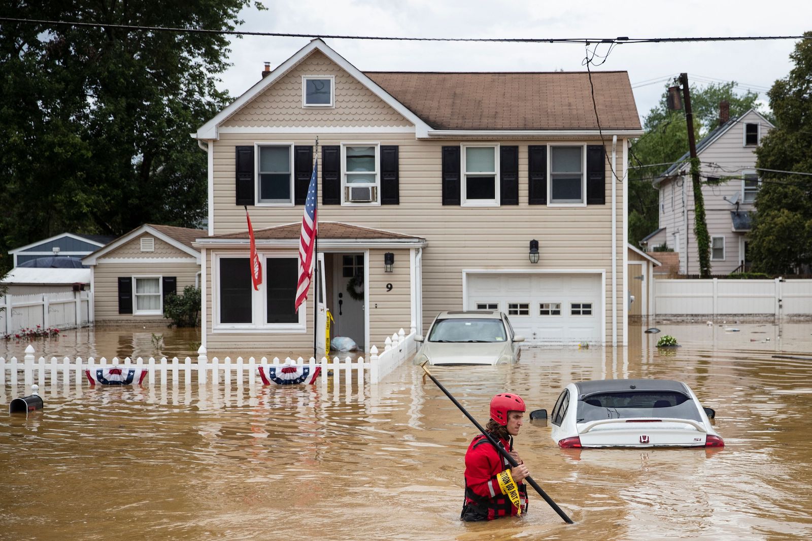 A New Market Volunteer Fire Company rescue crew member wades through high waters following a flash flood, as Tropical Storm Henri makes landfall, in Helmetta, New Jersey, on August 22, 2021.