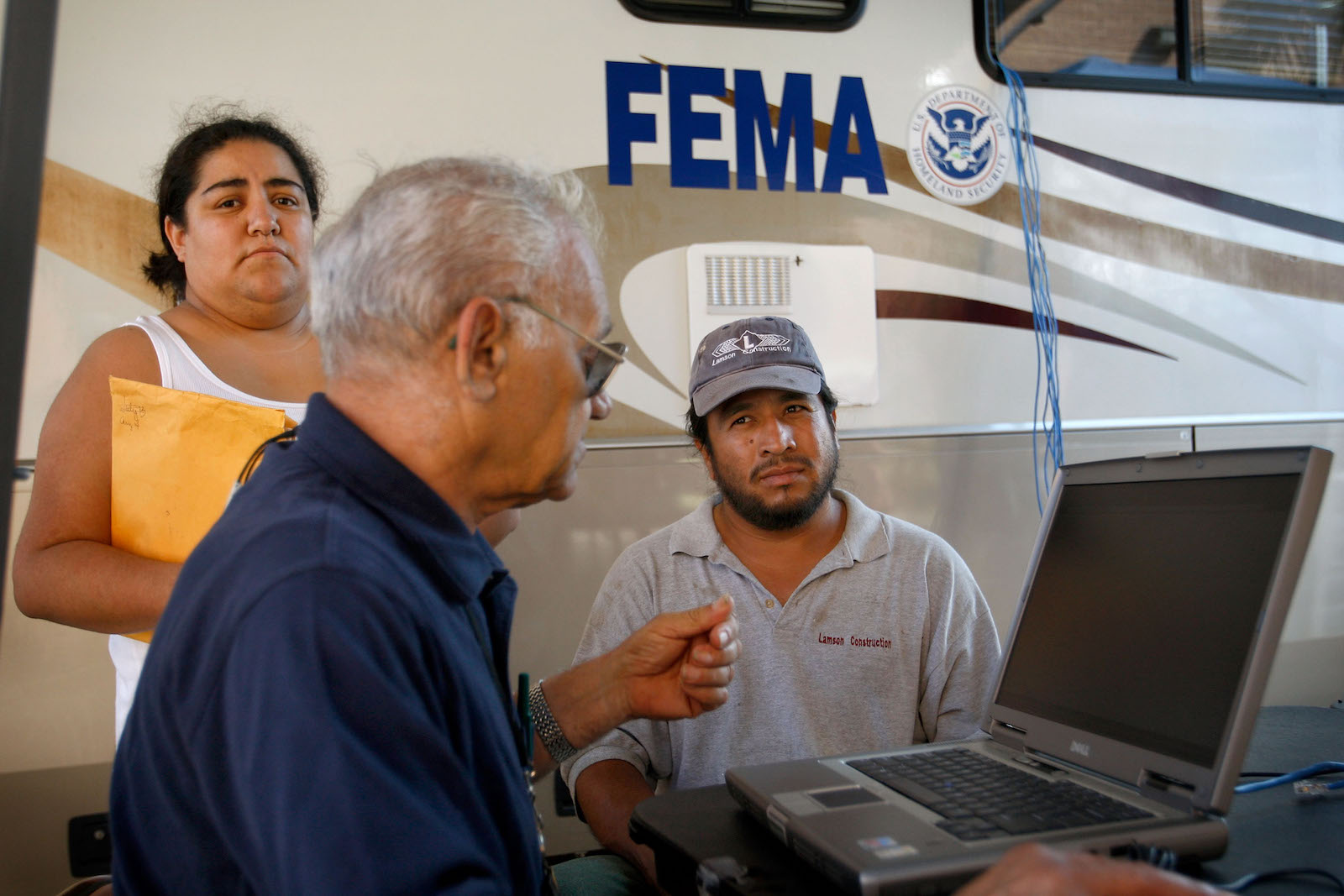 EMA representative Richard Dae (C) registers Victor Leos (R) and his wife Sanjuanita for assistance after their home was damaged during Hurricane Ike September 20, 2008 in Galveston, Texas.