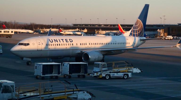 a united airlines plan sits at an airport gate