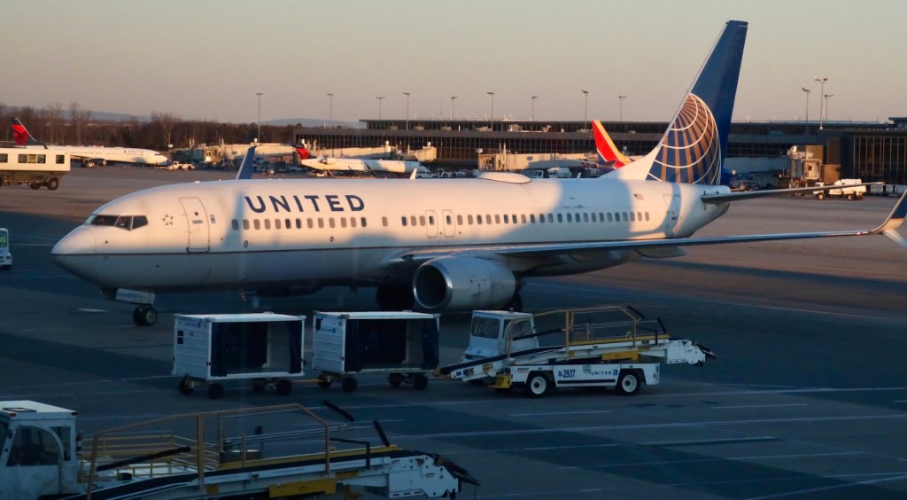 a united airlines plan sits at an airport gate