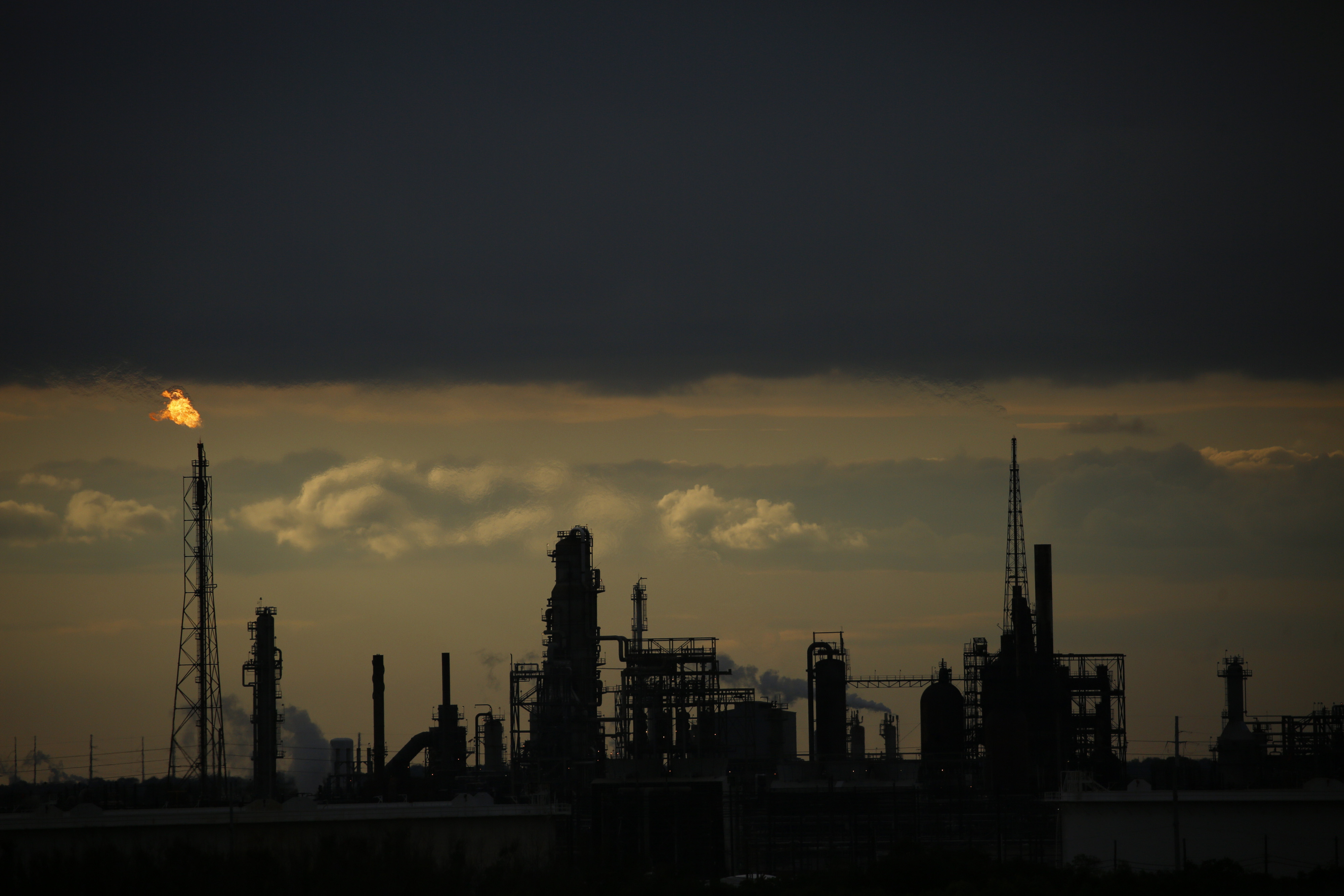 Flames from a flare stack at an oil refinery at dusk in Texas