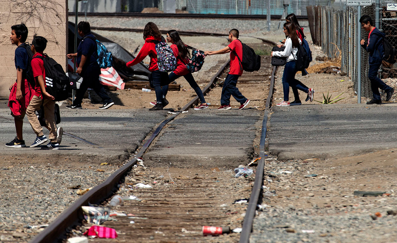Image of school children crossing derelict train tracks