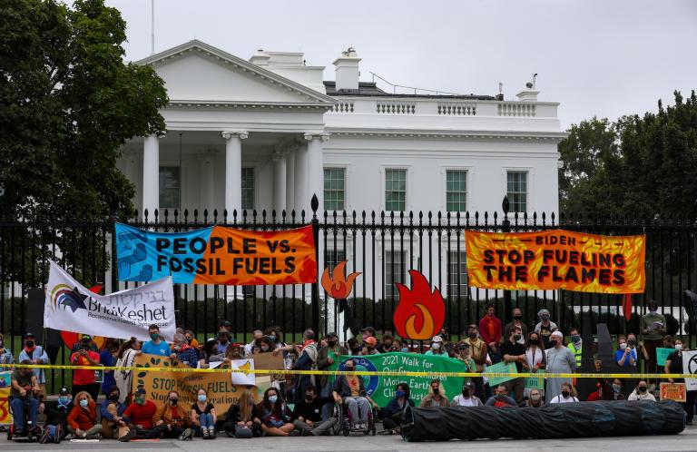 Protesters in front of white house with signs and banners