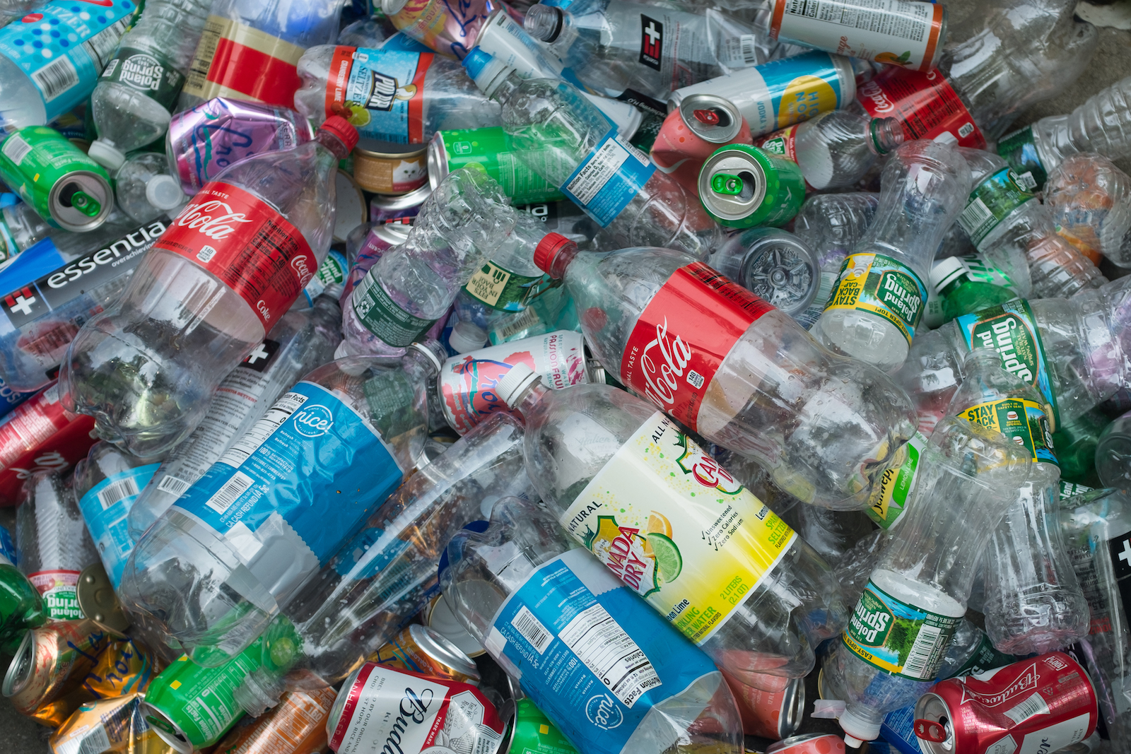 A large pile of plastic bottles and cans collected on a street corner in downtown Manhattan, New York.