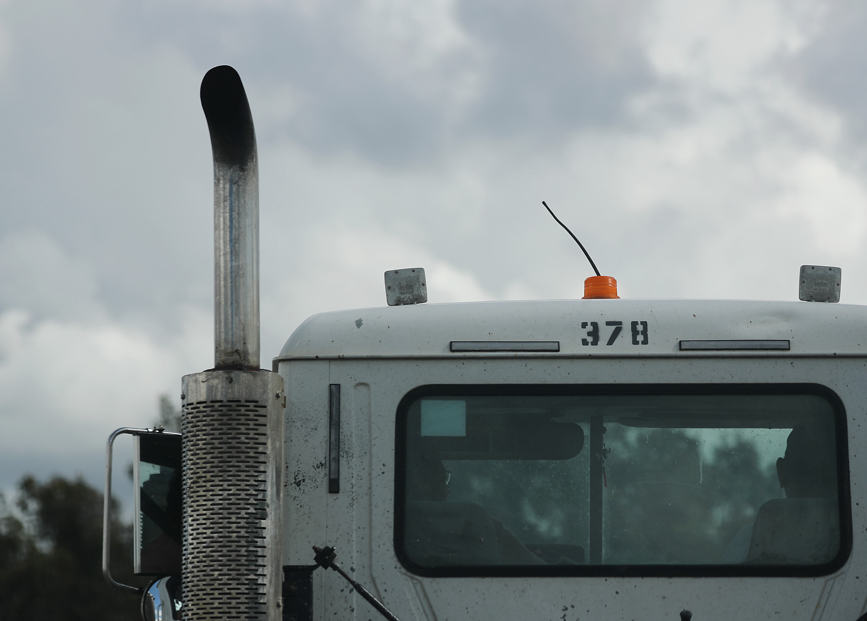 A semi-trailer truck cab and exhaust pipe seen from the rear