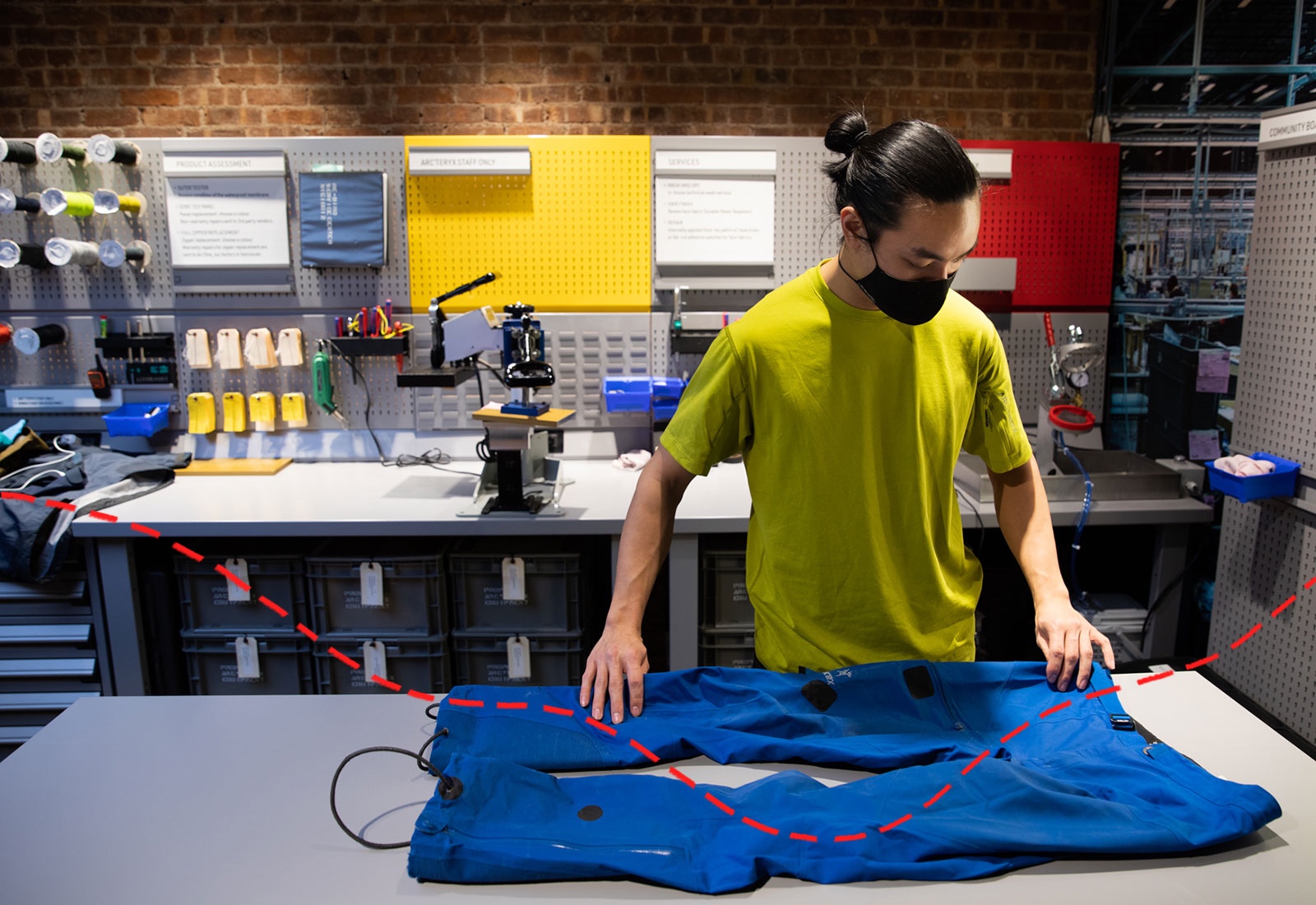Man laying out pants to mend on table