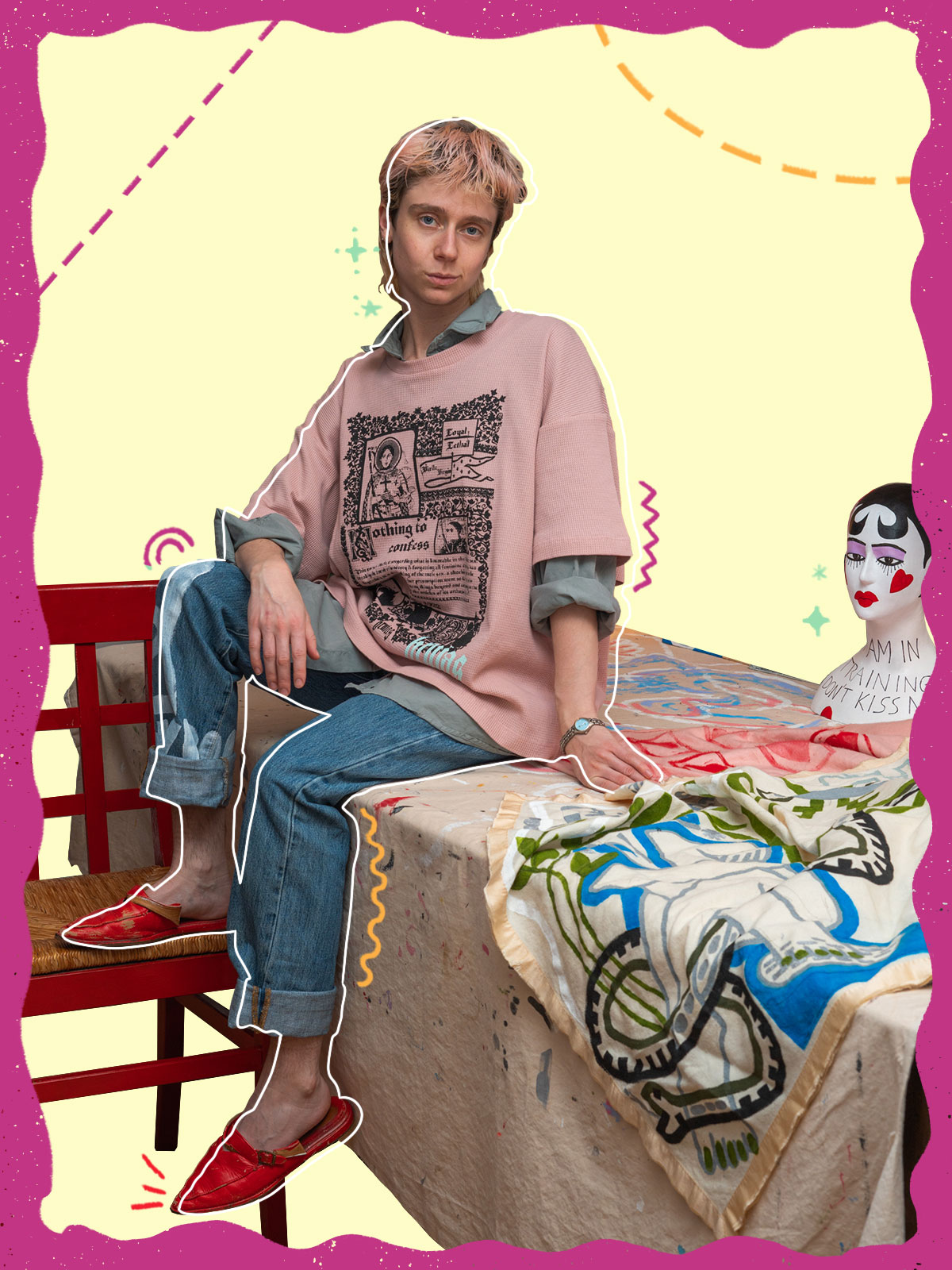 Person sitting on table with fabric and mannequin head with drawn graphics around them