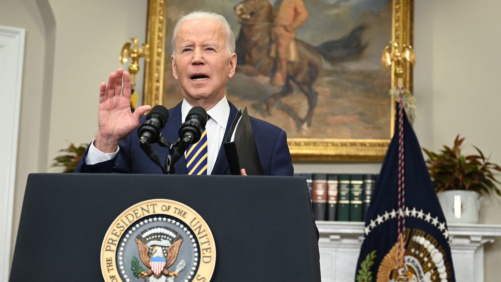 Biden at a podium beside a flag of the presidential seal.