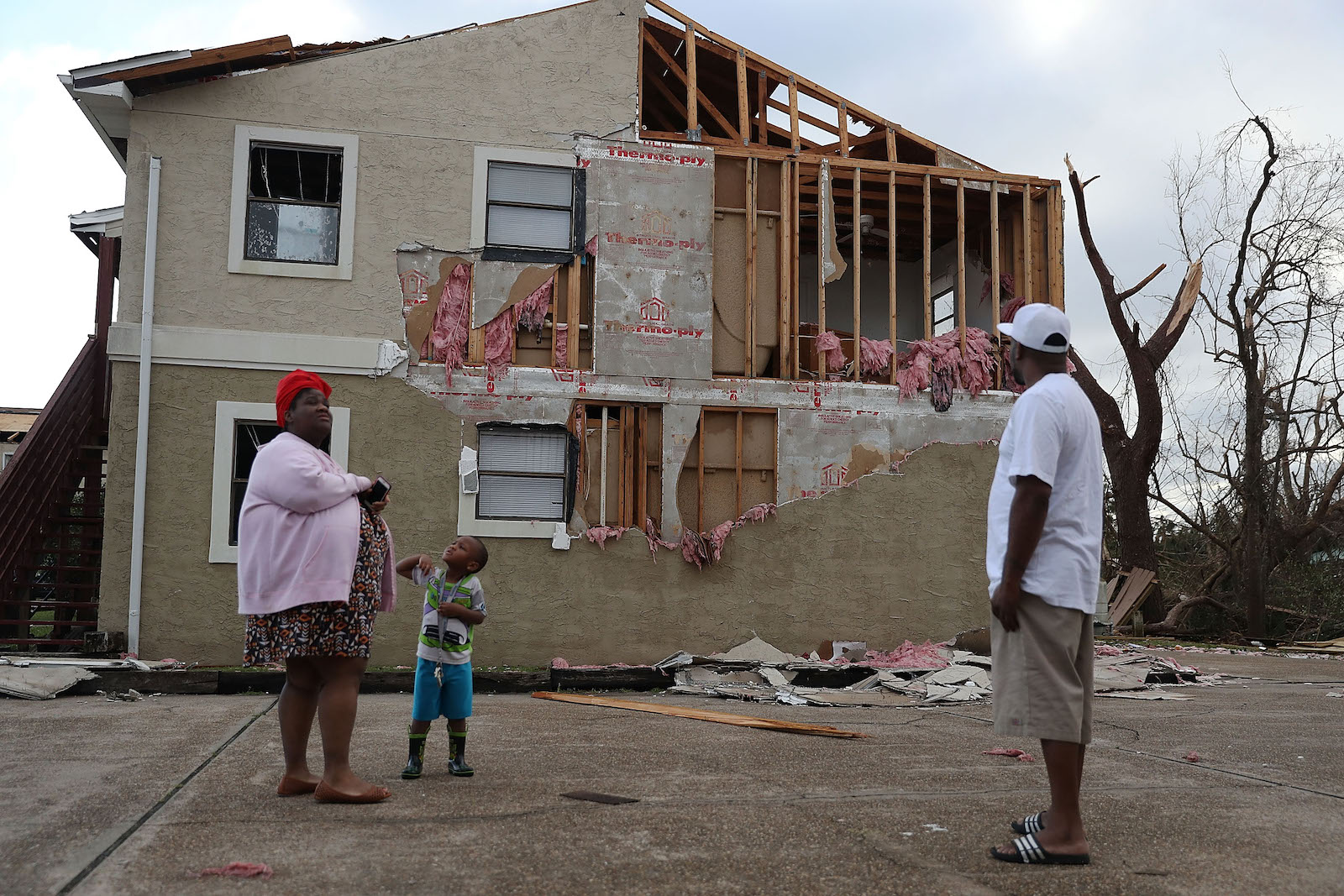 Comeasha Stanley, Ramari Stanley and Terrell Atkinson stand near a heavily damaged apartment after Hurricane Michael passed through the area on October 11, 2018 in Panama City, Florida. The hurricane hit the Florida Panhandle as a category 4 storm.