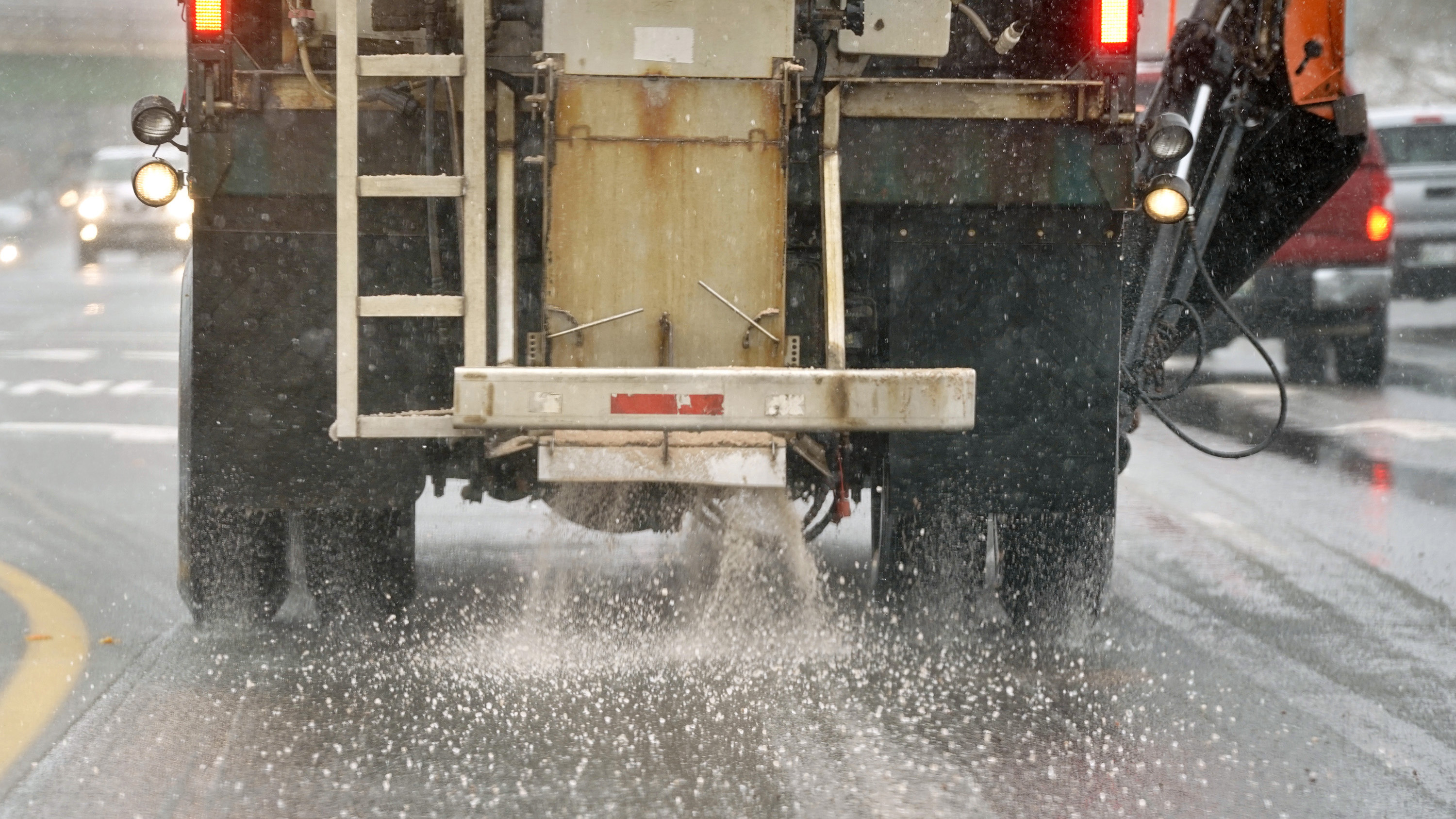 A truck spreads salt on a road in Maine.