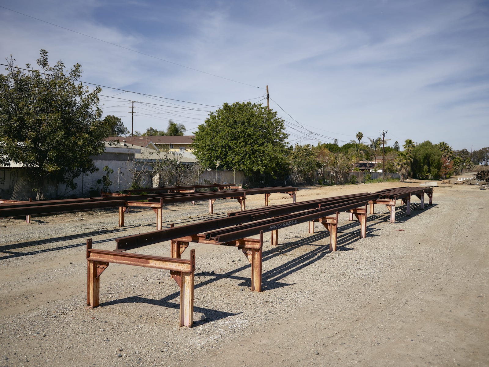 railroad tracks on raised platform pillars near backyards