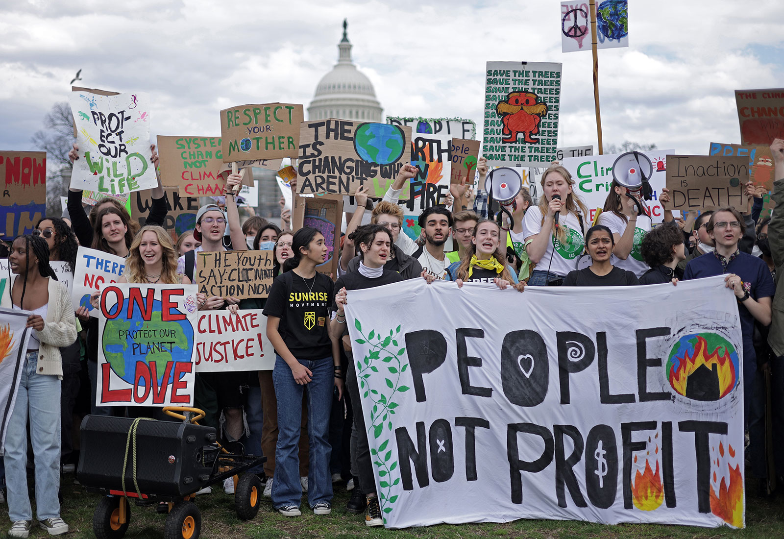 Large group of young people protesting climate change with USA capitol building in background