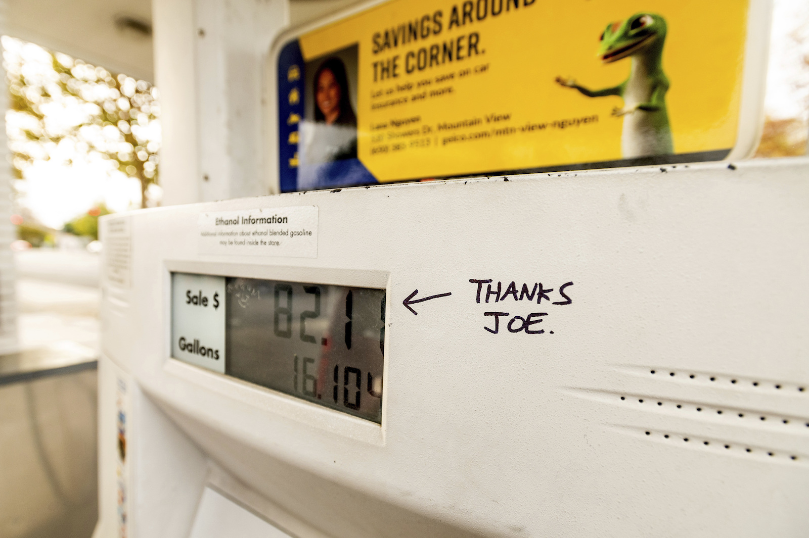 a white gas pump with a hand-drawn message in black pen saying 