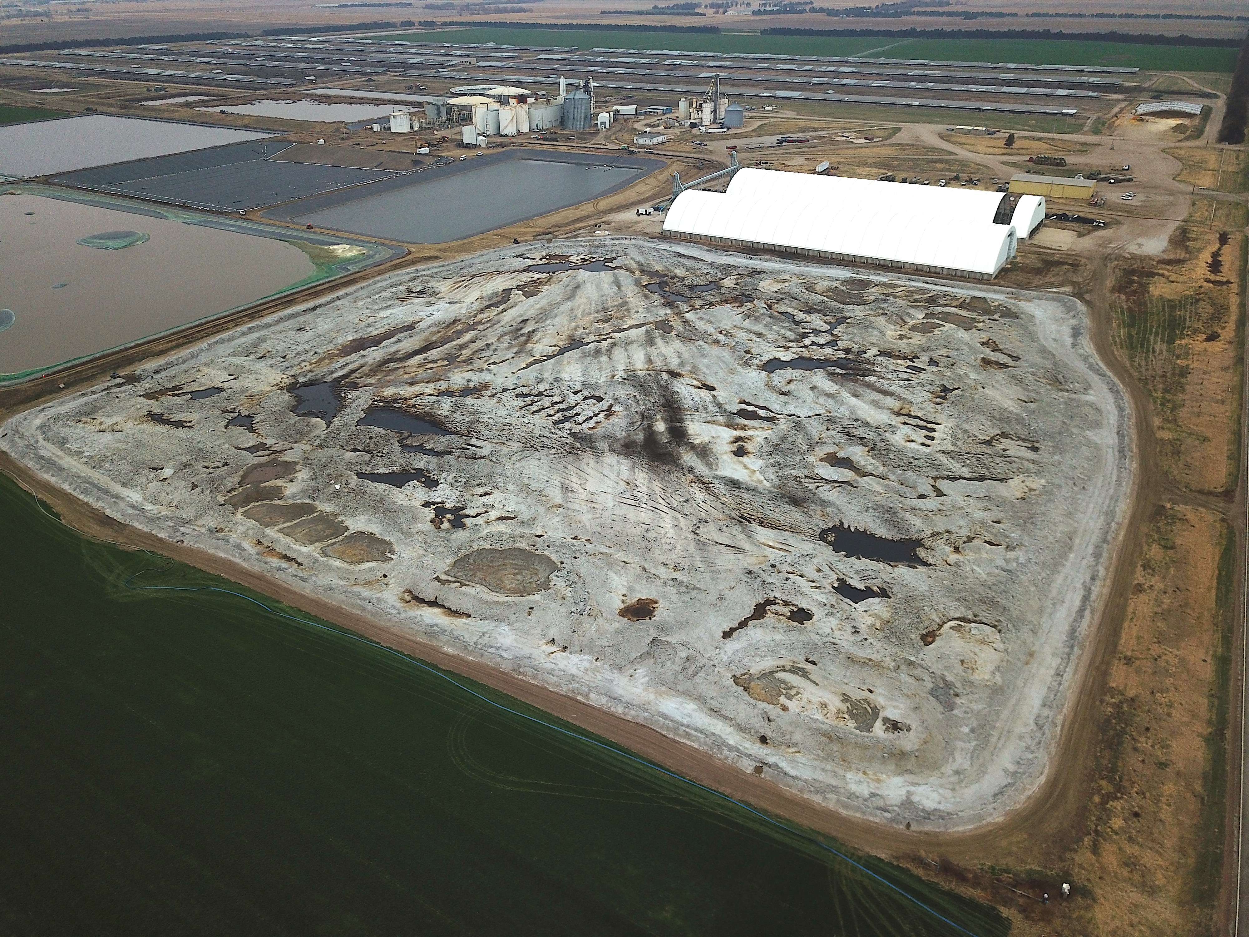 A view from the air shows the pile of waste covered in a gray coating.