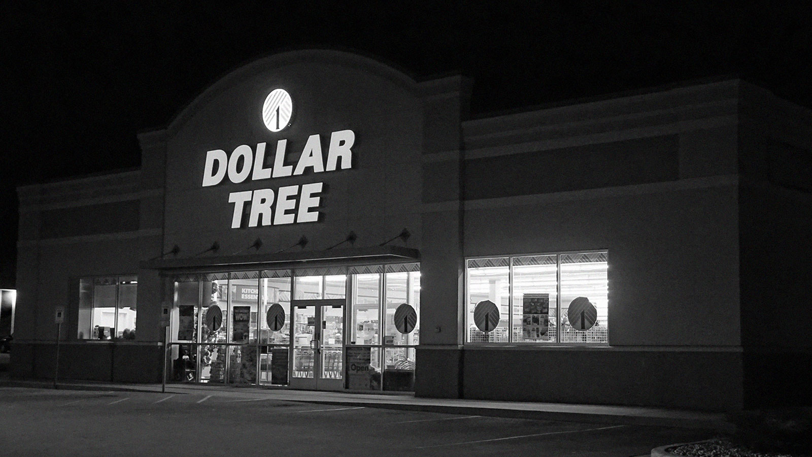 Black and white picture of the front of a Dollar Tree store at night