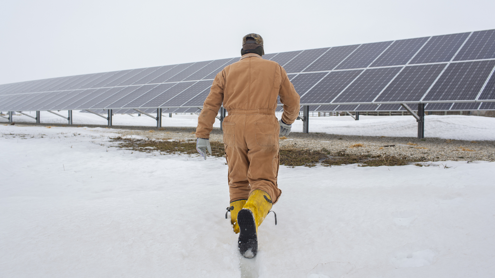 A man walks toward a solar panel in Illinois.