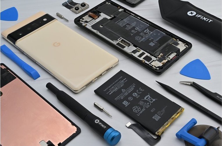 Various smartphones; some are open to show the battery and interior, along with a mix of different tools to fix the phones