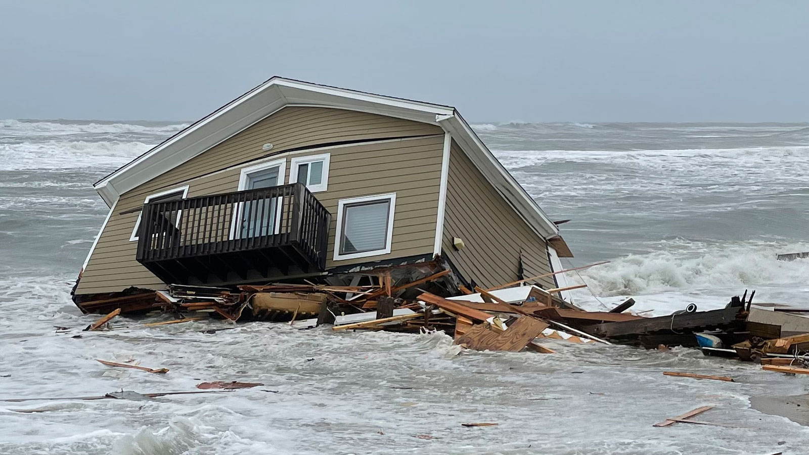 House collapsed into the ocean with debris around it