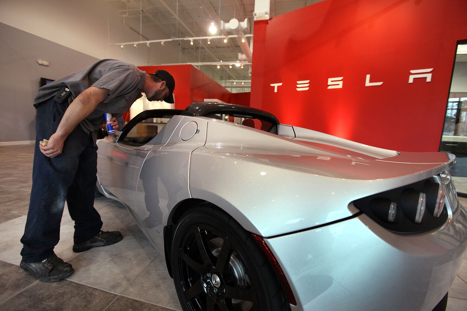 a man inspects a tesla electric car