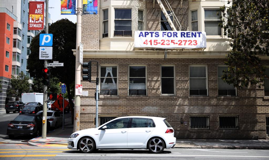 An apartment building with a sign advertising apartments for rent