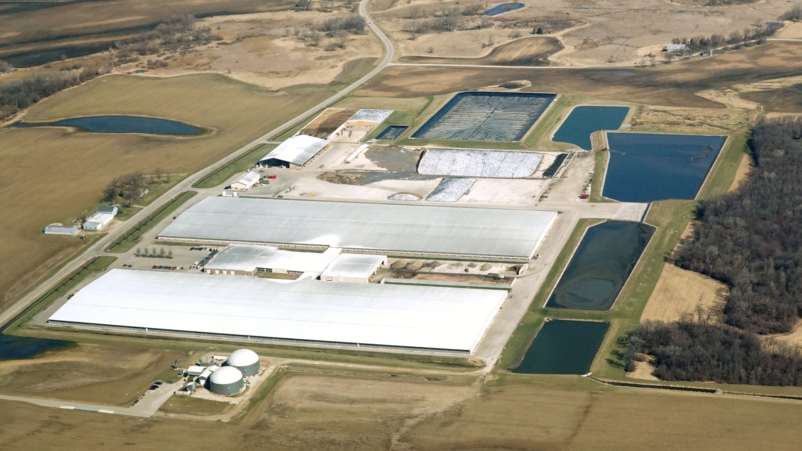 Aerial view of a concentrated animal feeding operation (CAFO) in Wisconsin. Large windowless buildings, waste lagoons, and barns are visible