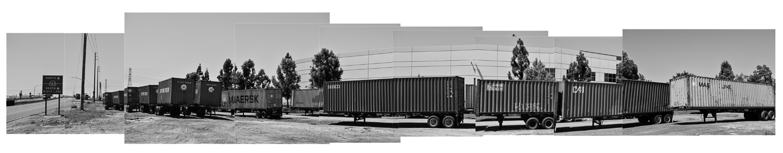 Black and white panoramic image made from multiple photos of semi trailers