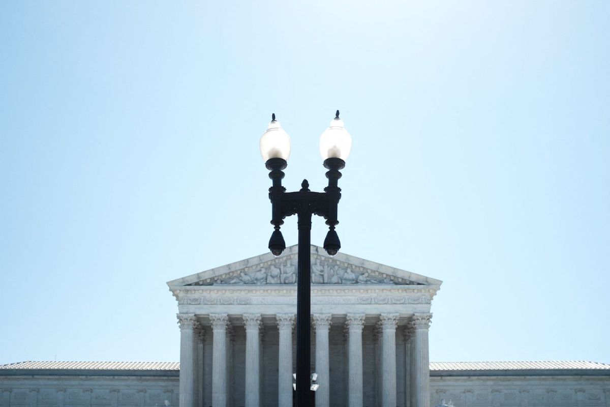 a lamp post stands in front of the supreme court building