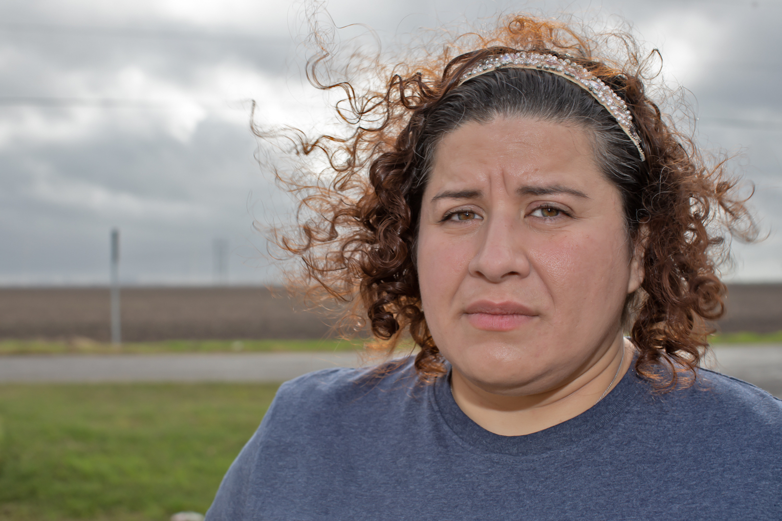 Elida Castillo on her uncle, Jose G. Garcia's lawn in Taft that has a view of the Exxon-SABIC plant.