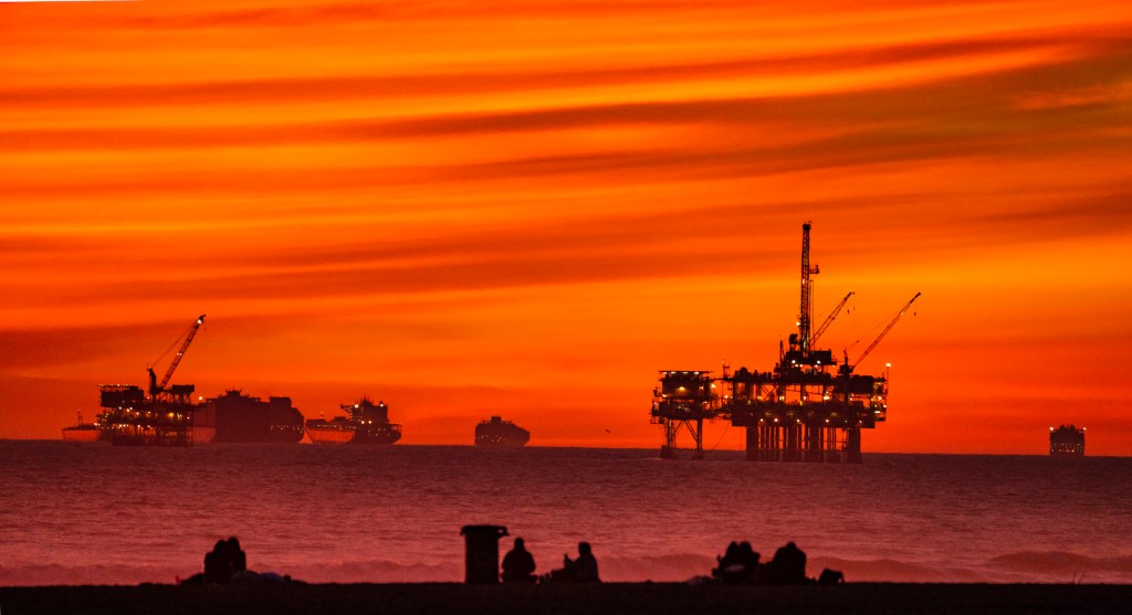 offshore oil platforms during a blood red sunset