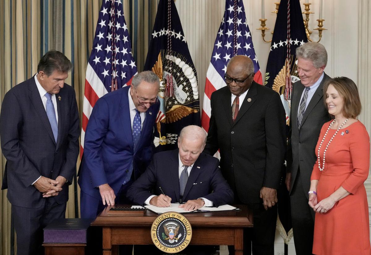 Biden signs a bill surrounded by other Democratic leaders