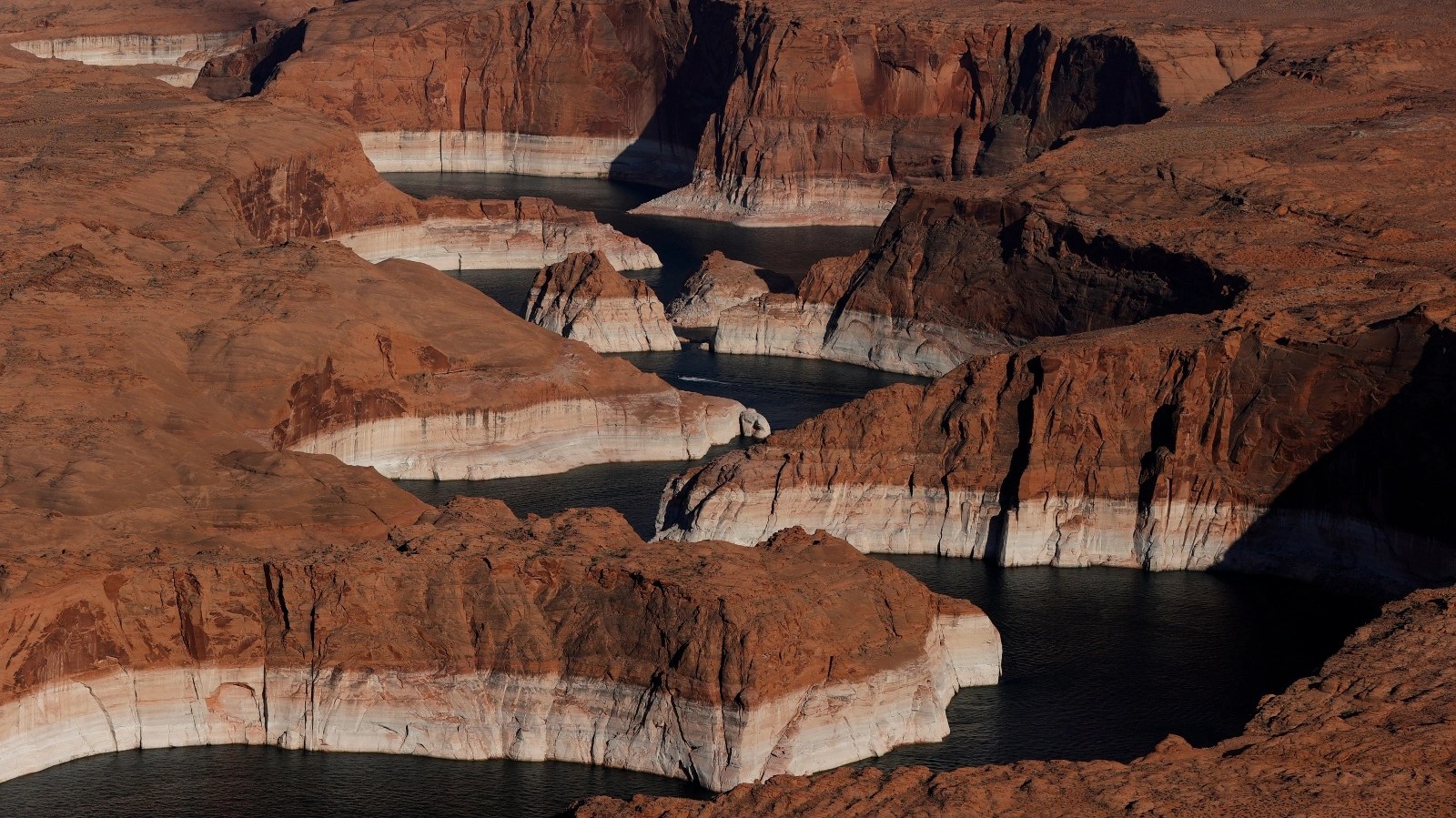 Aerial view of bleached sections of rock surrounding Lake Powell, showing the amount the water level has dropped due to climate change
