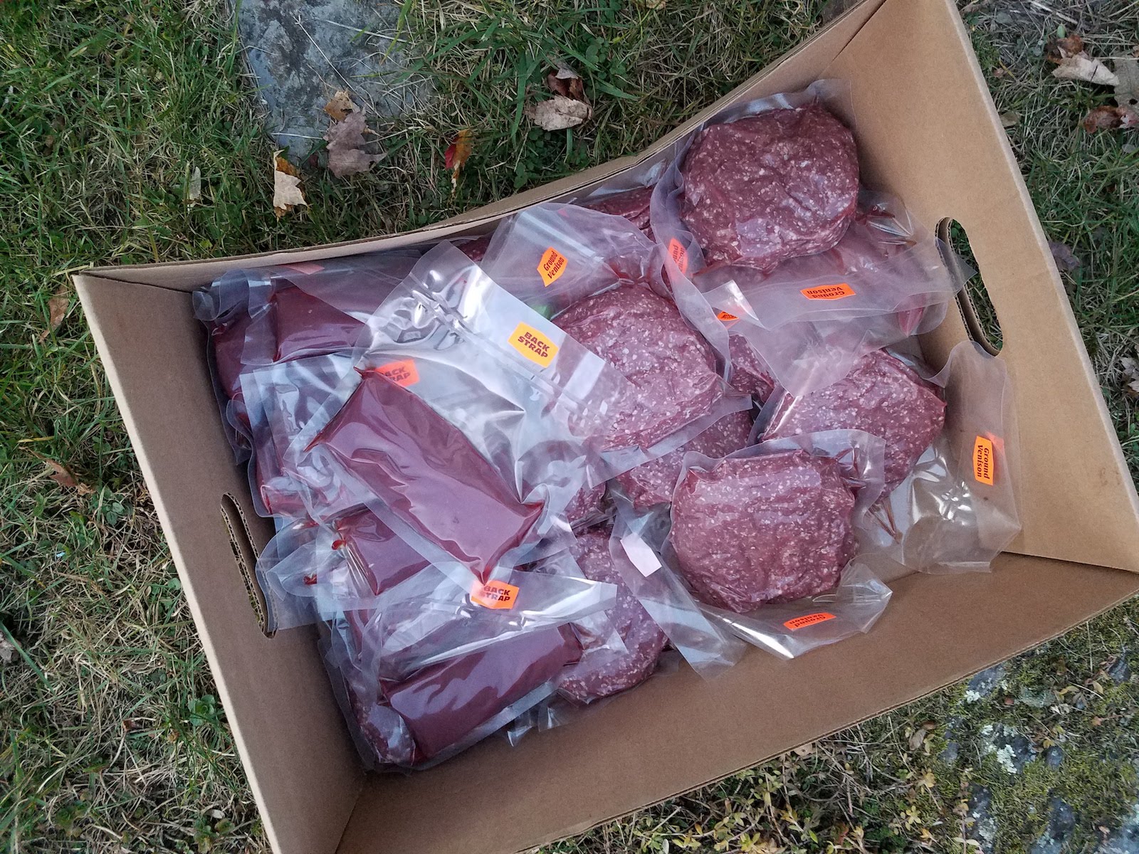 a cardboard box with packaged ground meat inside
