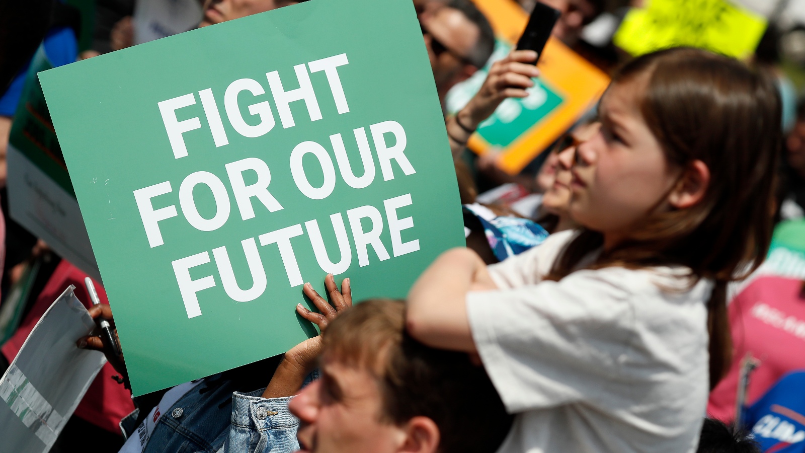 A sign at a busy protest says "fight for our future"