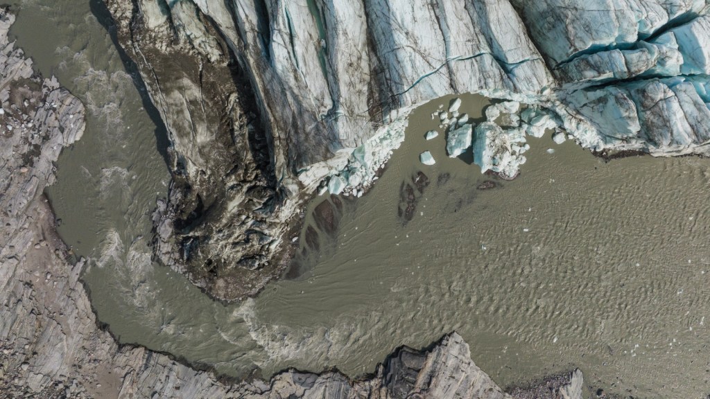 Aerial view of an ice sheet and brown meltwater