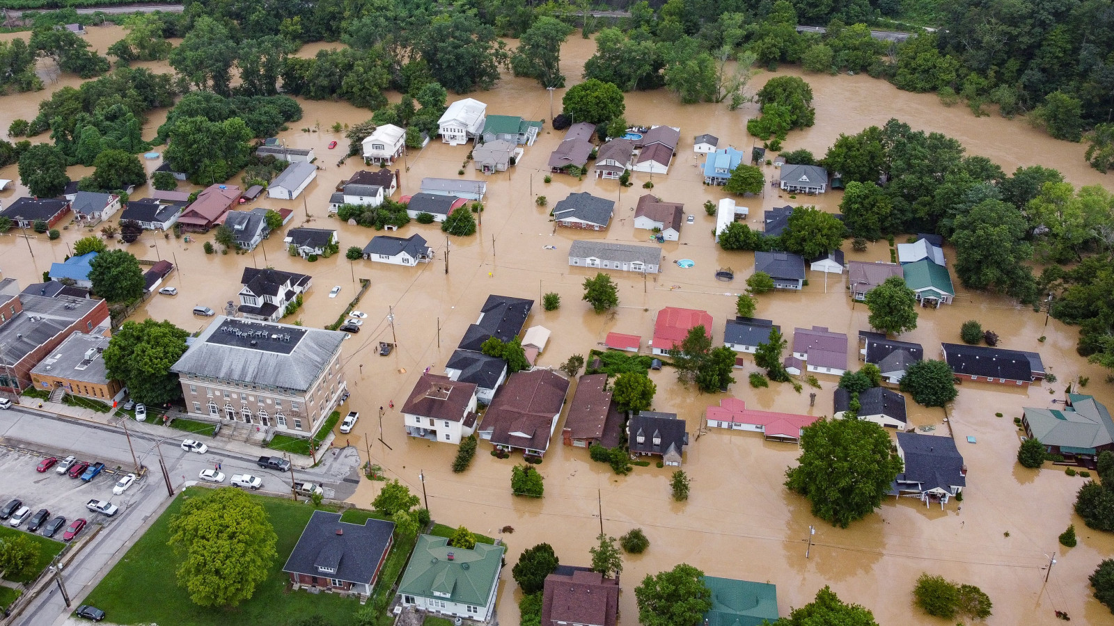 Aerial view of homes submerged under flood waters from the North Fork of the Kentucky River in Jackson, Kentucky, on July 28, 2022. - Flash flooding caused by torrential rains has killed at least eight people in eastern Kentucky and left some residents stranded on rooftops and in trees, the governor of the south-central US state said Thursday.
