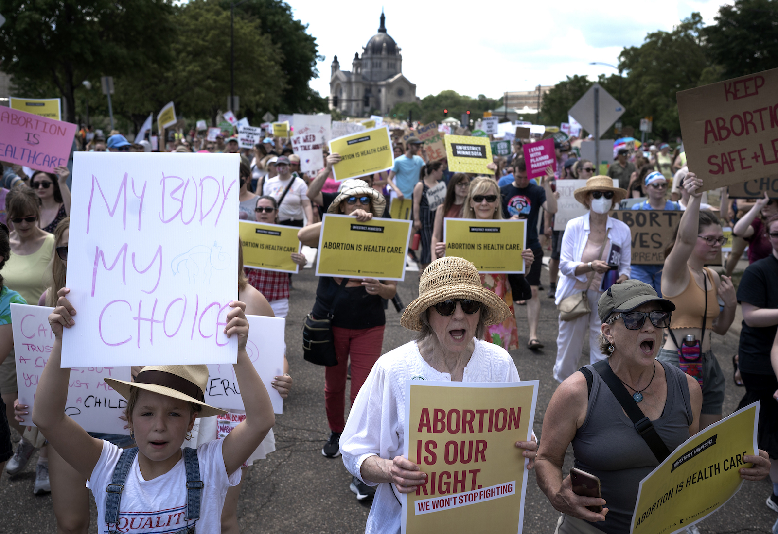 Protesters march with signs saying "abortion is our right."