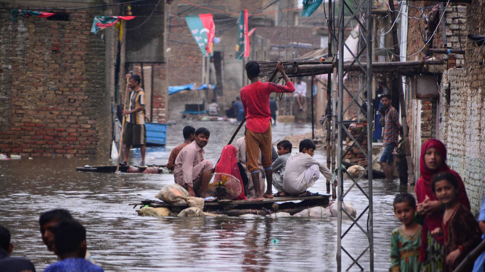 People use a raft to move along a waterlogged street in a residential area after a heavy monsoon rainfall in Hyderabad City in Pakistan