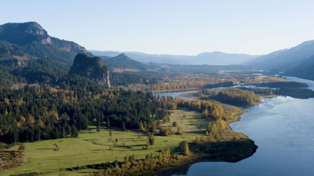 Aerial view of Columbia River Gorge with mountains, trees, and a river