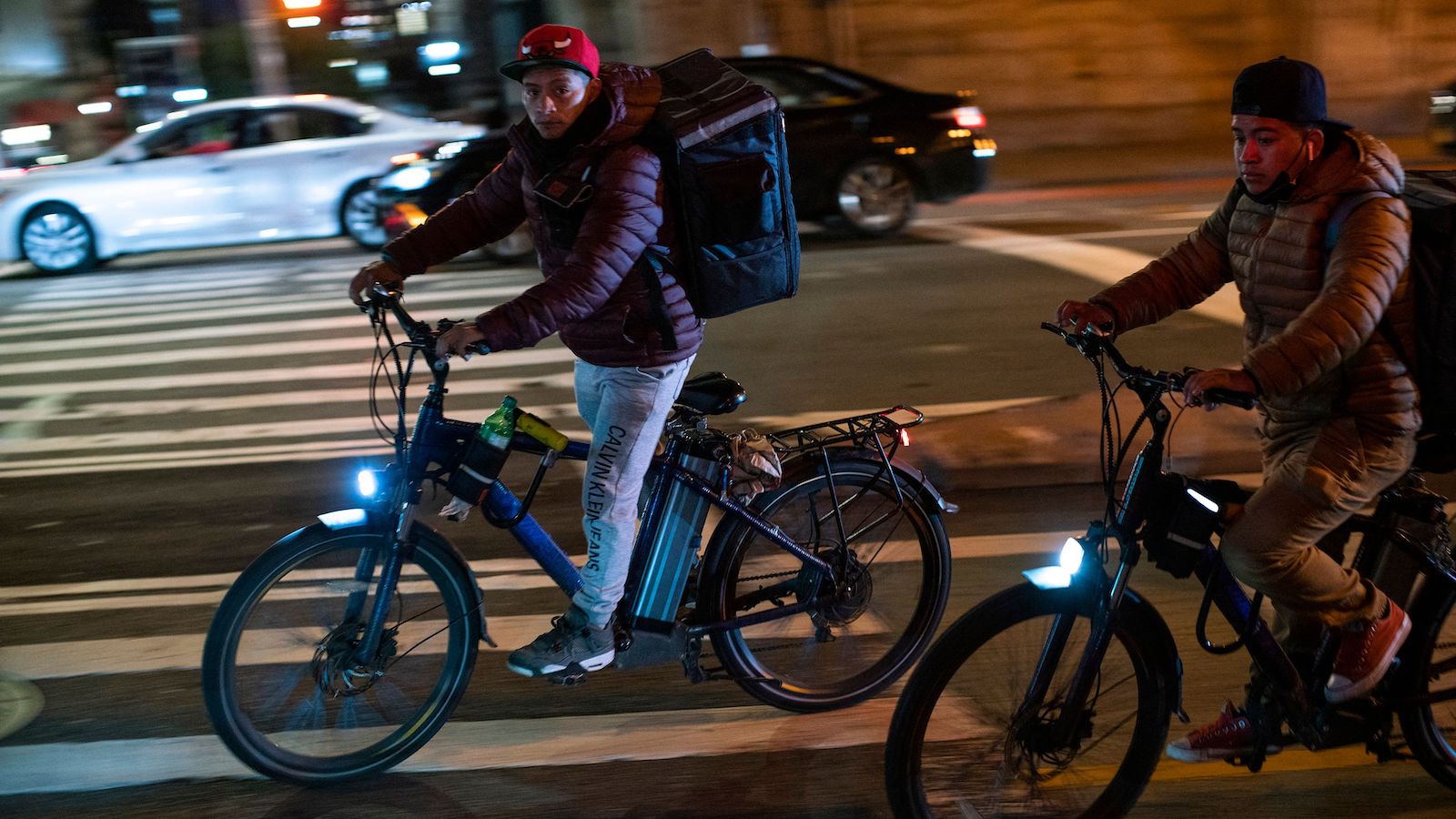 Delivery workers ride their bikes in the Manhattan borough of New York on October 27, 2021.