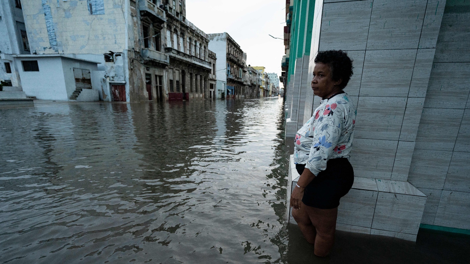 A woman stands on a flooded street in Havana after the passage of hurricane Ian.