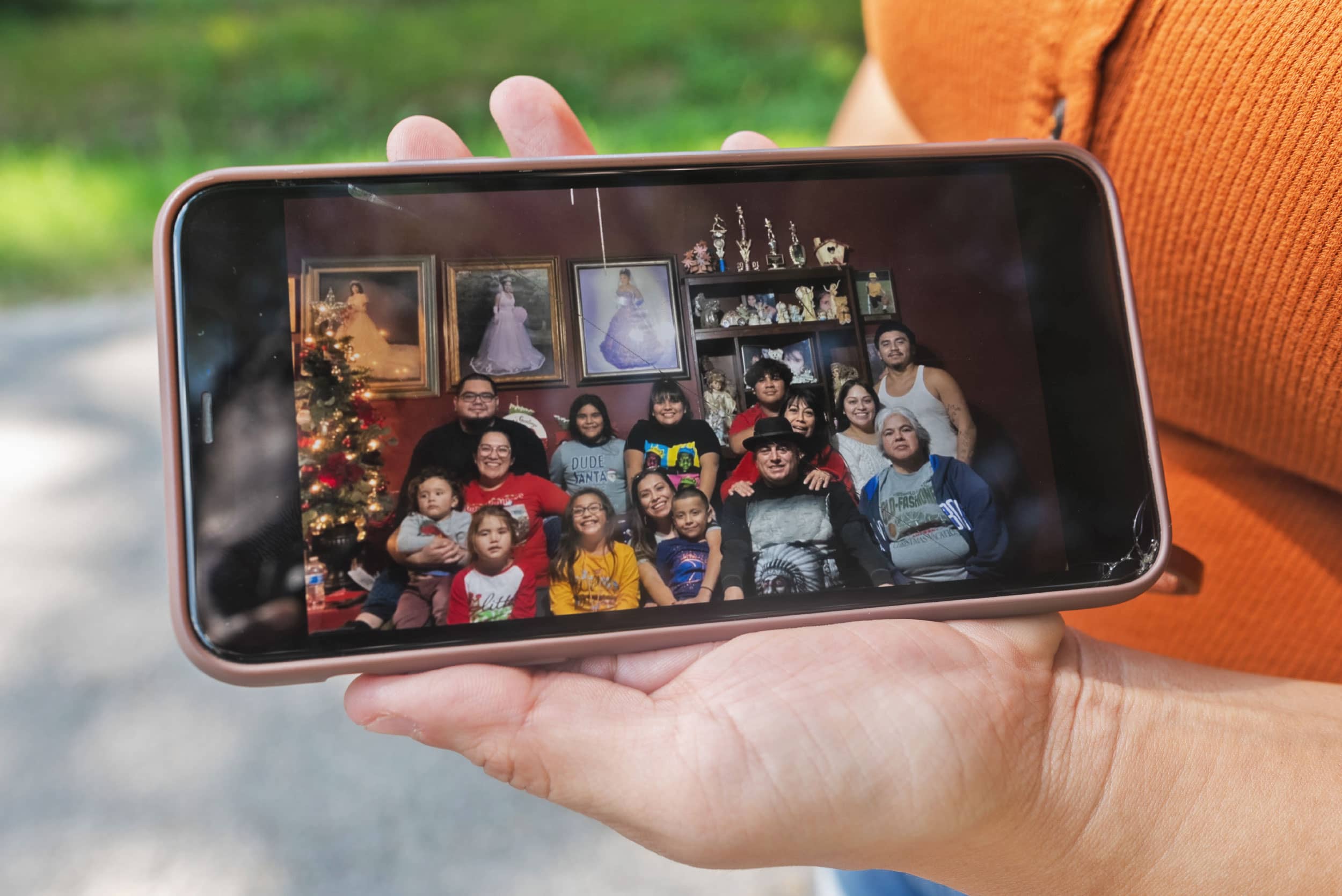 A woman uses her phone to show a photo of one of her family's final Christmases