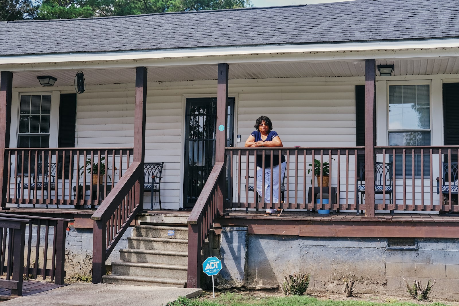 Woman stands on the porch of her parents’ home in Princeville, North Carolina