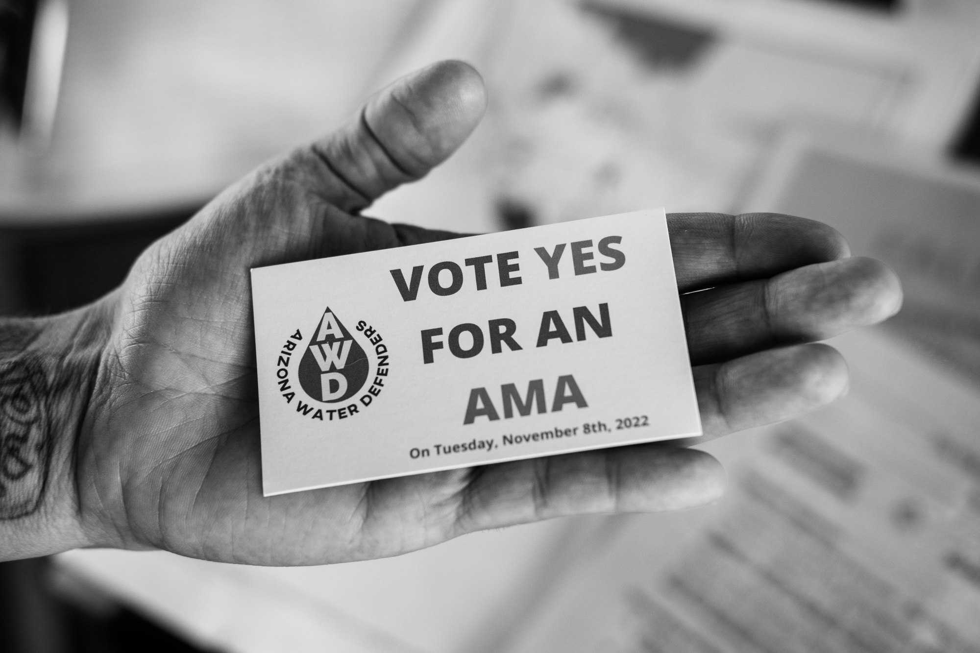 a hand holds a card that says vote yes for an ama