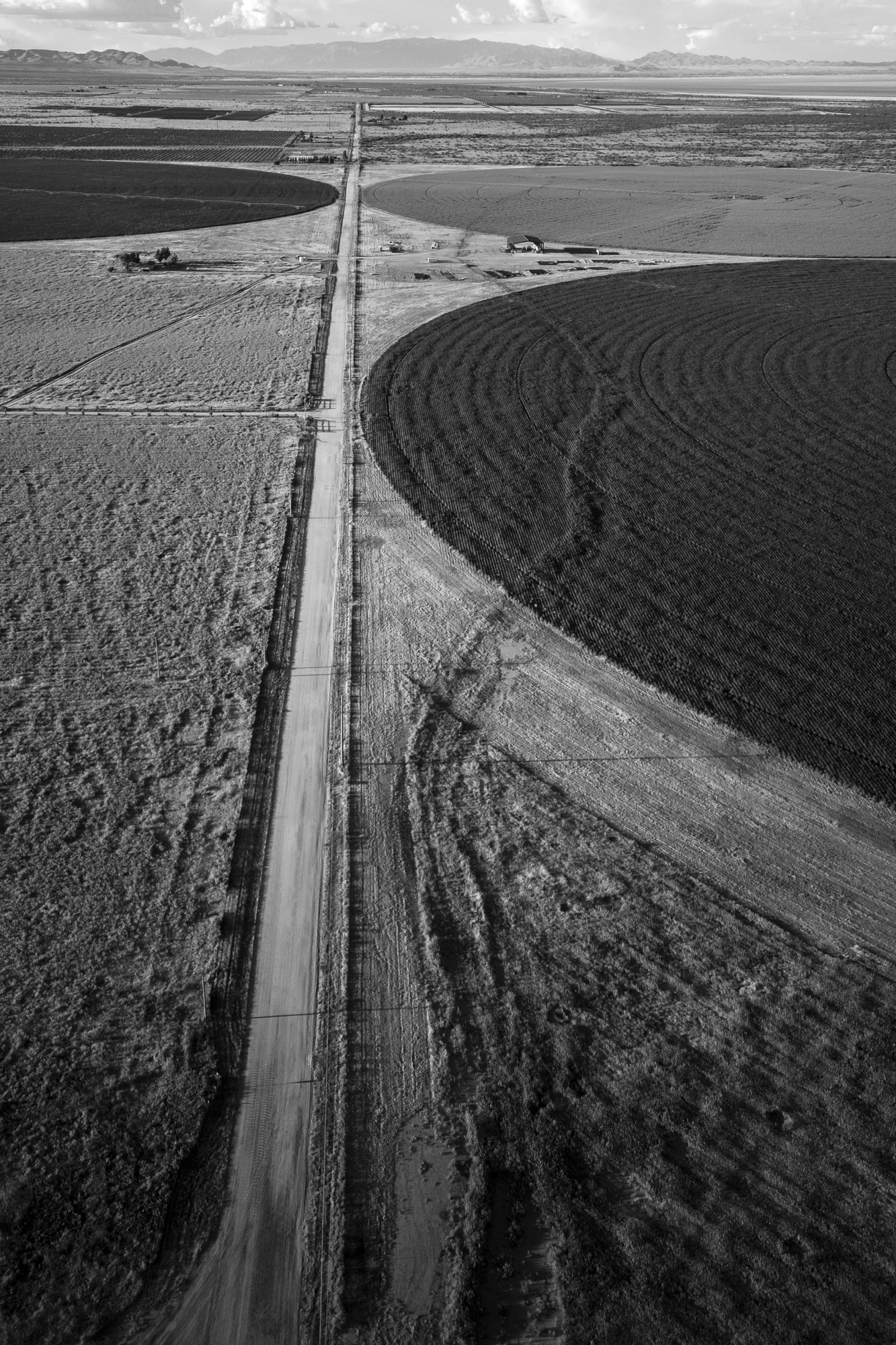 a road near a large circular field has a long jagged line running along the earth